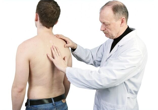 Doctor examines the back with osteochondrosis